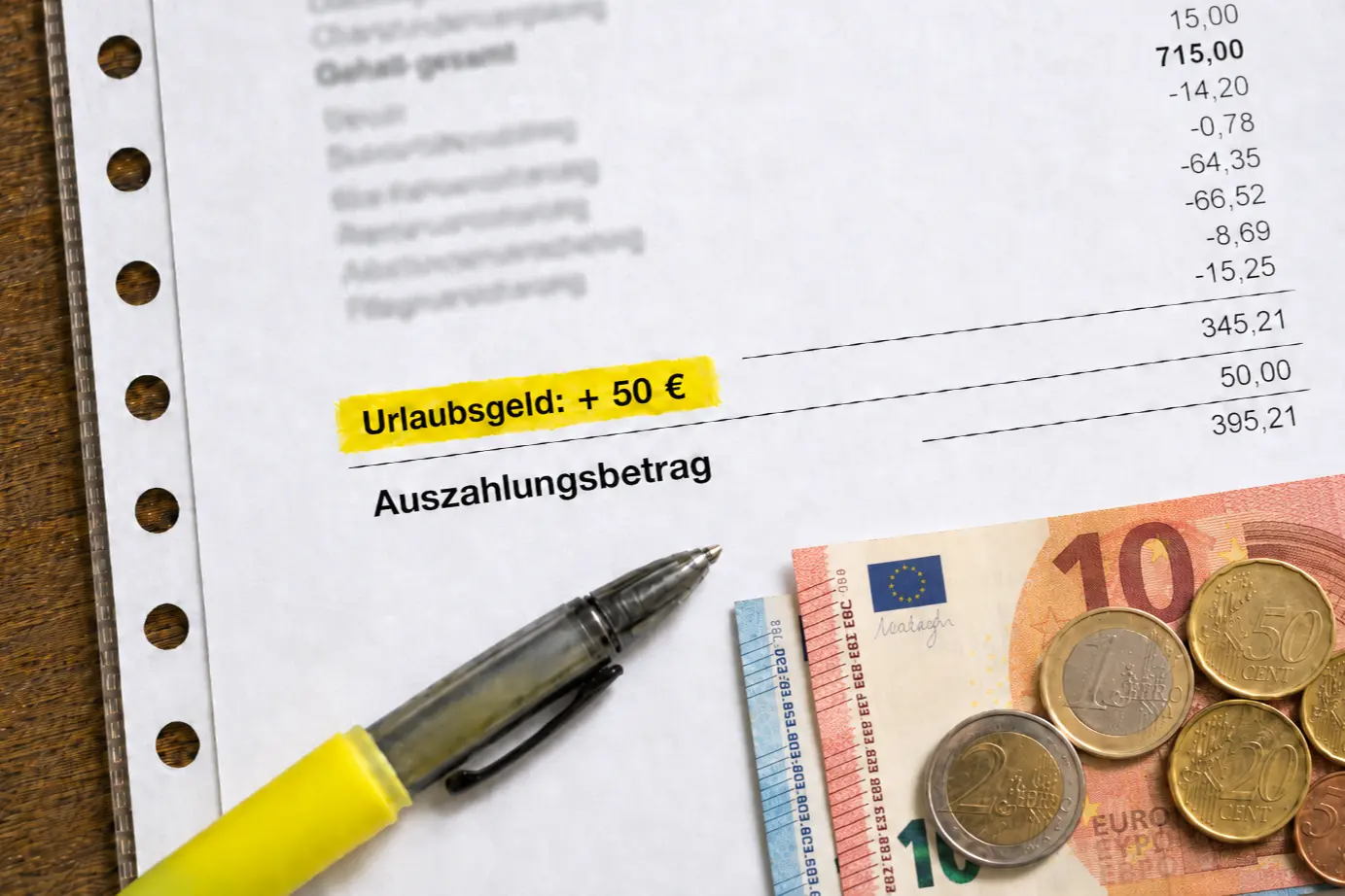 Lohnabrechnung mit markiertem Urlaubsgeld von 50 Euro, Eurogeld und Auszahlungsbetrag beim Bürgergeld.